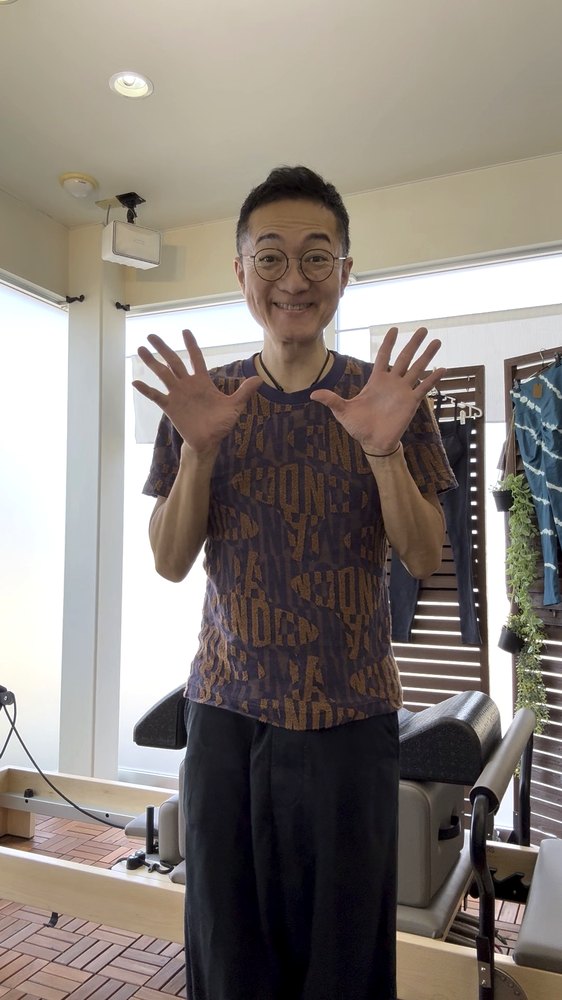 両手を広げて笑うあきらっち